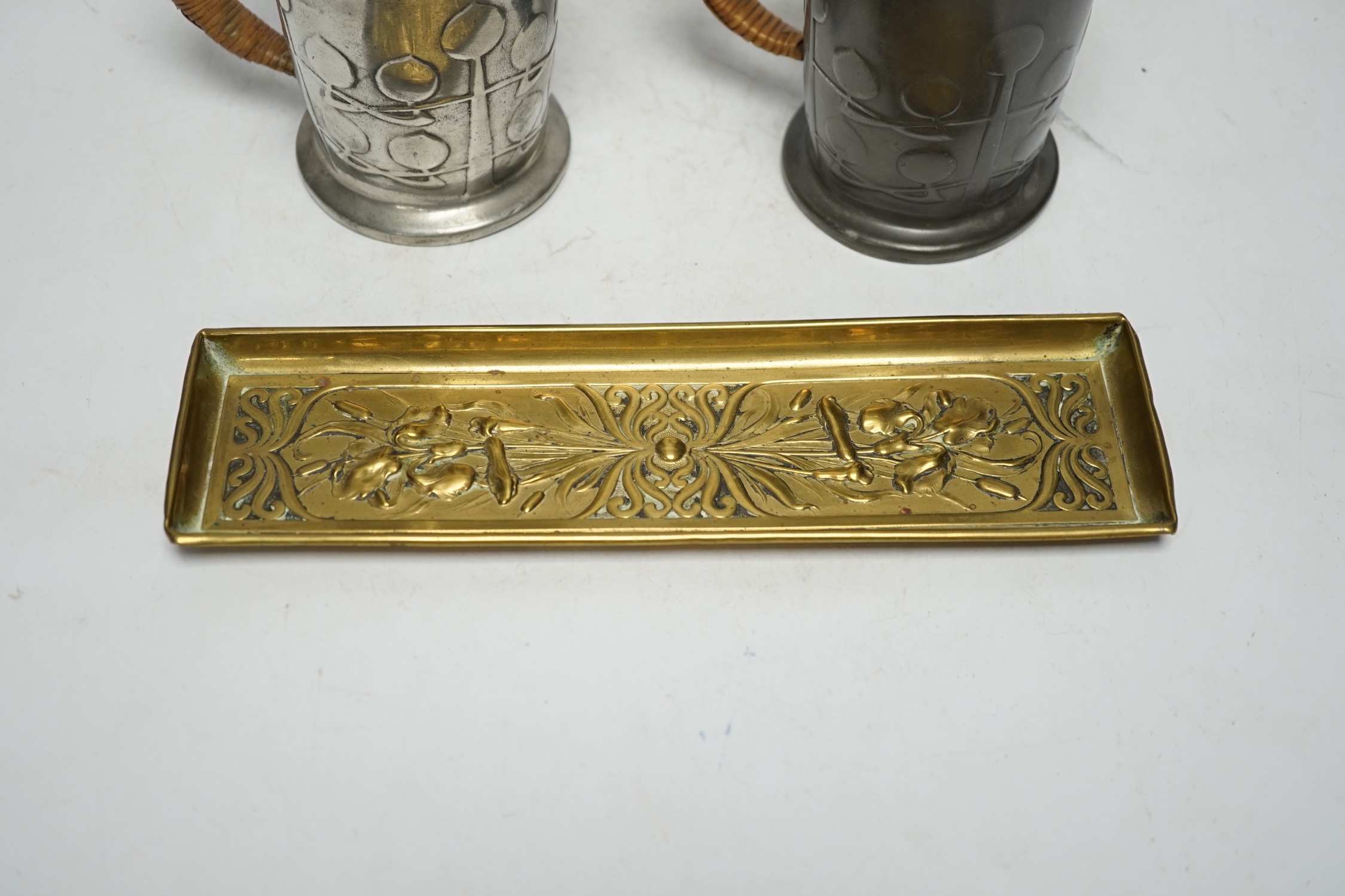 Archibald Knox (1864-1933) for Liberty & Co, two Tudric hot water jugs and an Art Nouveau brass pen tray, tray 24cm long (3). Condition - fair to good